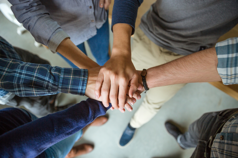 Group of people joining hands as a symbol of partnership